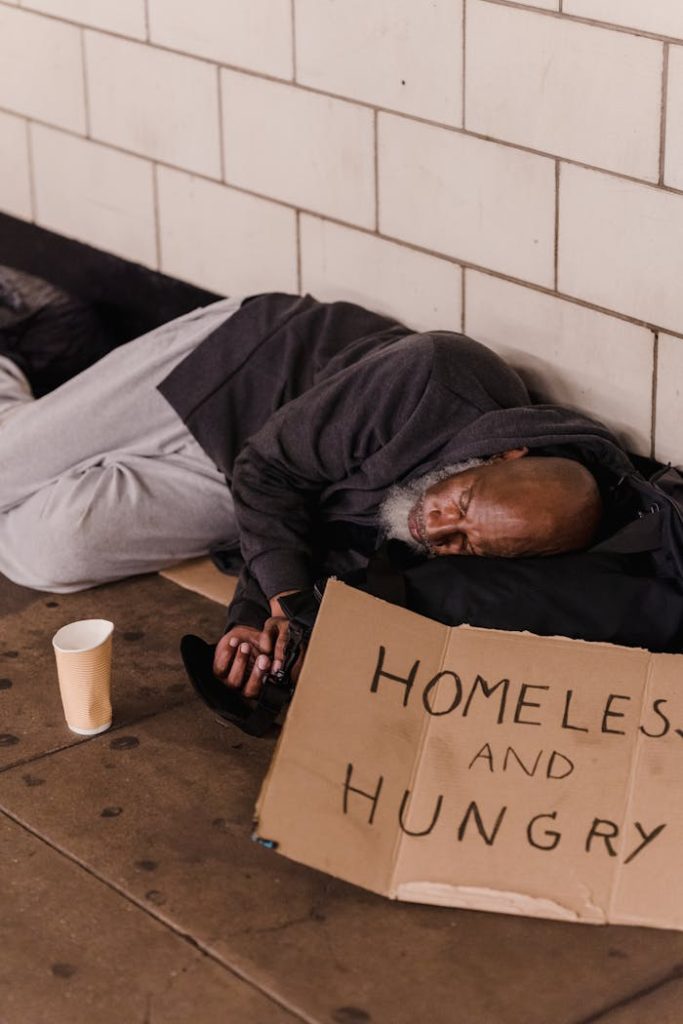 an-elderly-man-sleeping-on-the-floor-beside-a-wall-9533304 Elderly homeless man asleep on sidewalk with cardboard sign, Homeless and Hungry.
