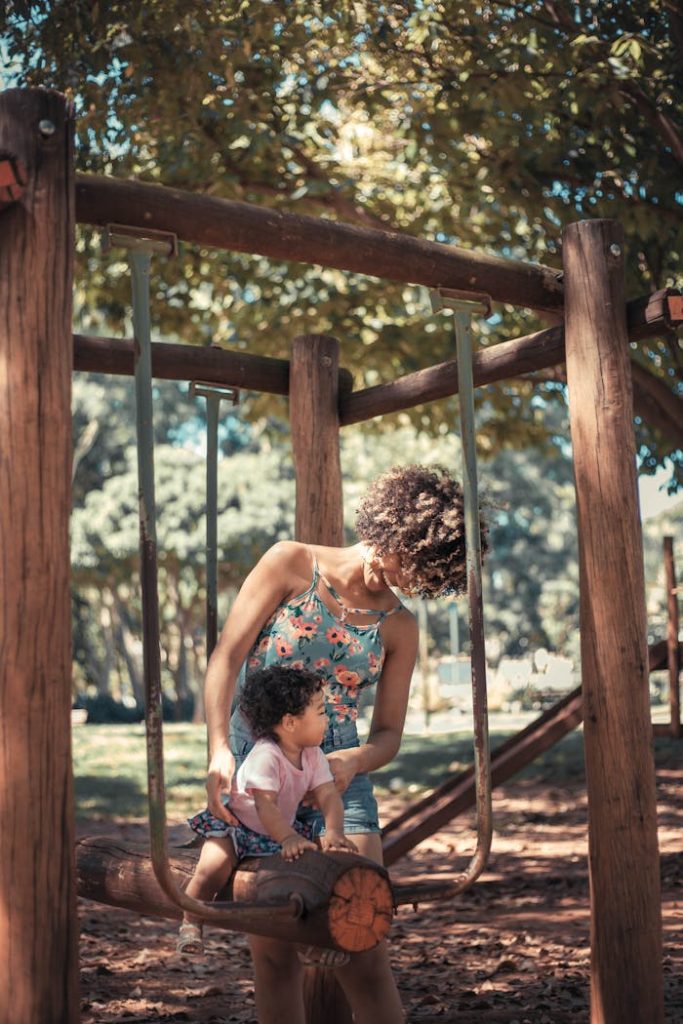 Joyful moment of a mother and child playing together in a sunny park, enjoying family time.